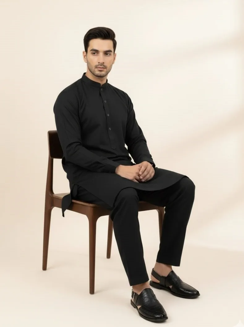 model sitting wearing black shalwar kameez and black peshawari chappal